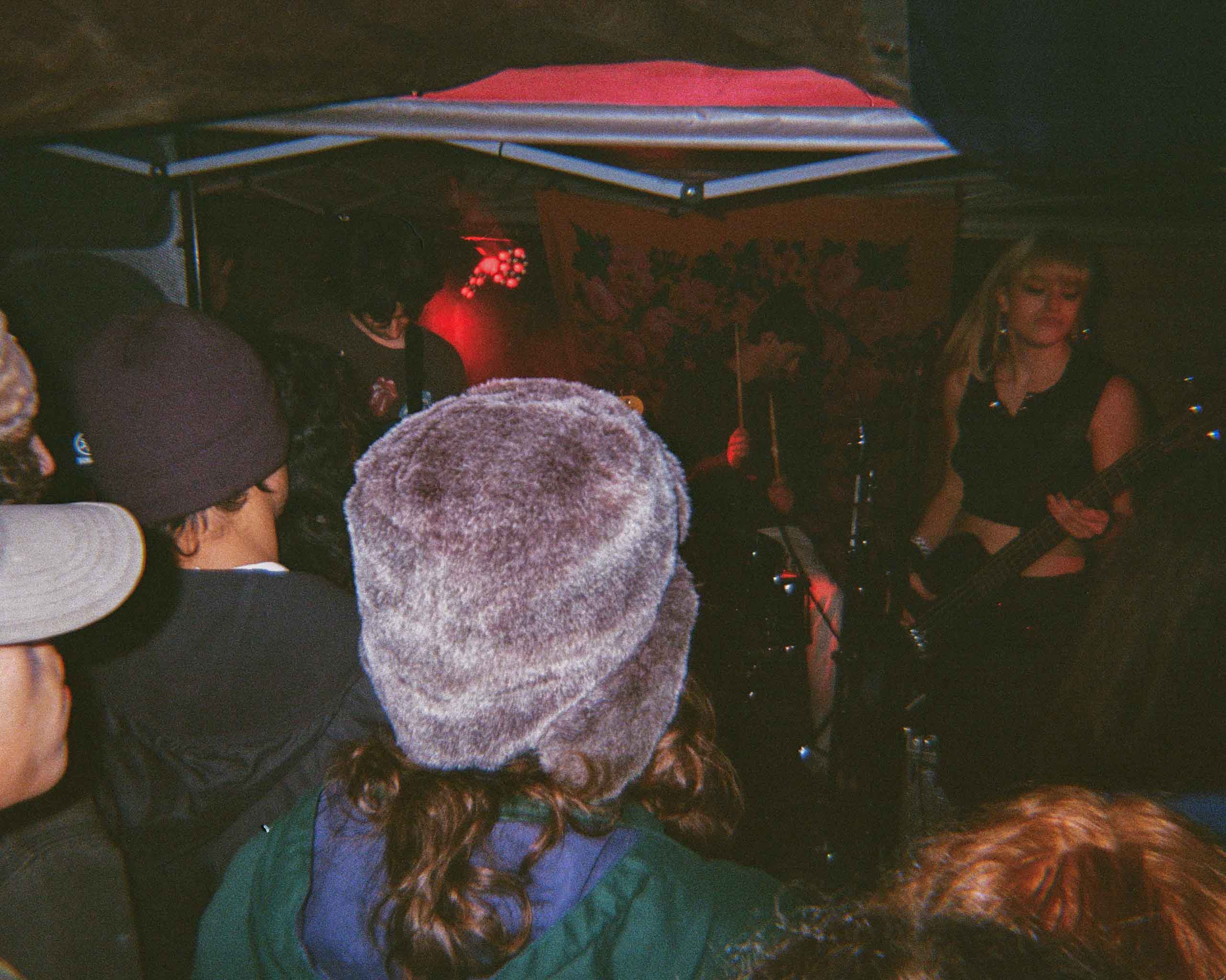 A band performing at a show partially blocked by the crowd.