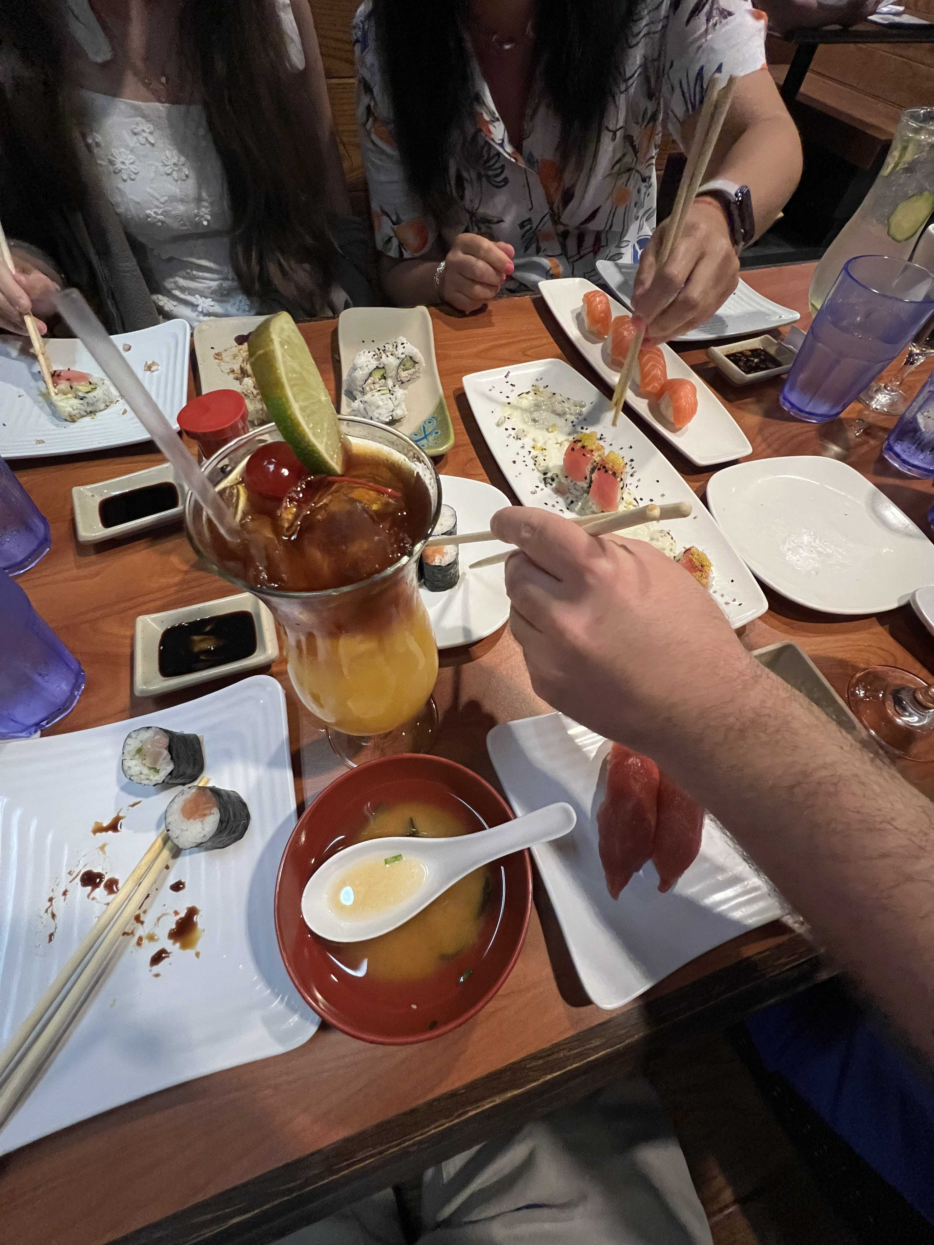 A table full of sushi plates and drinks.