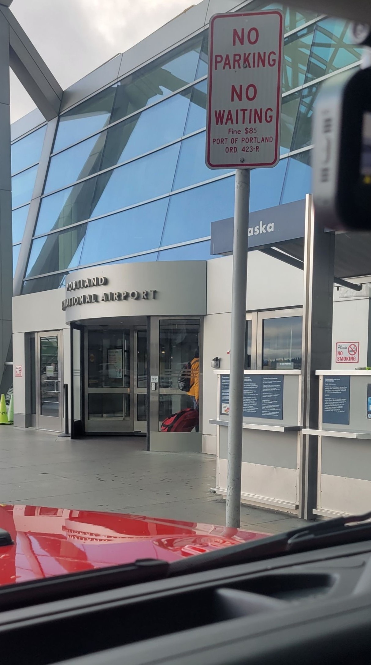 Boyan walking through a revolving door into the PDX airport.