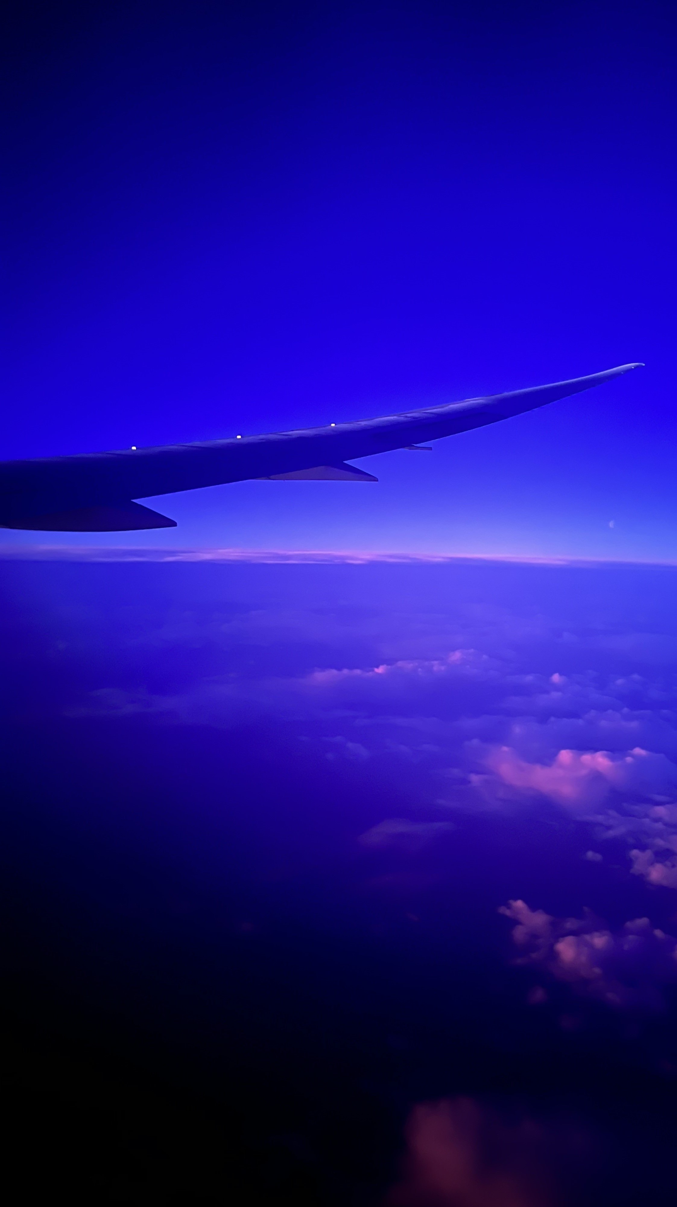 The sunset sky above the clouds from a plane window.