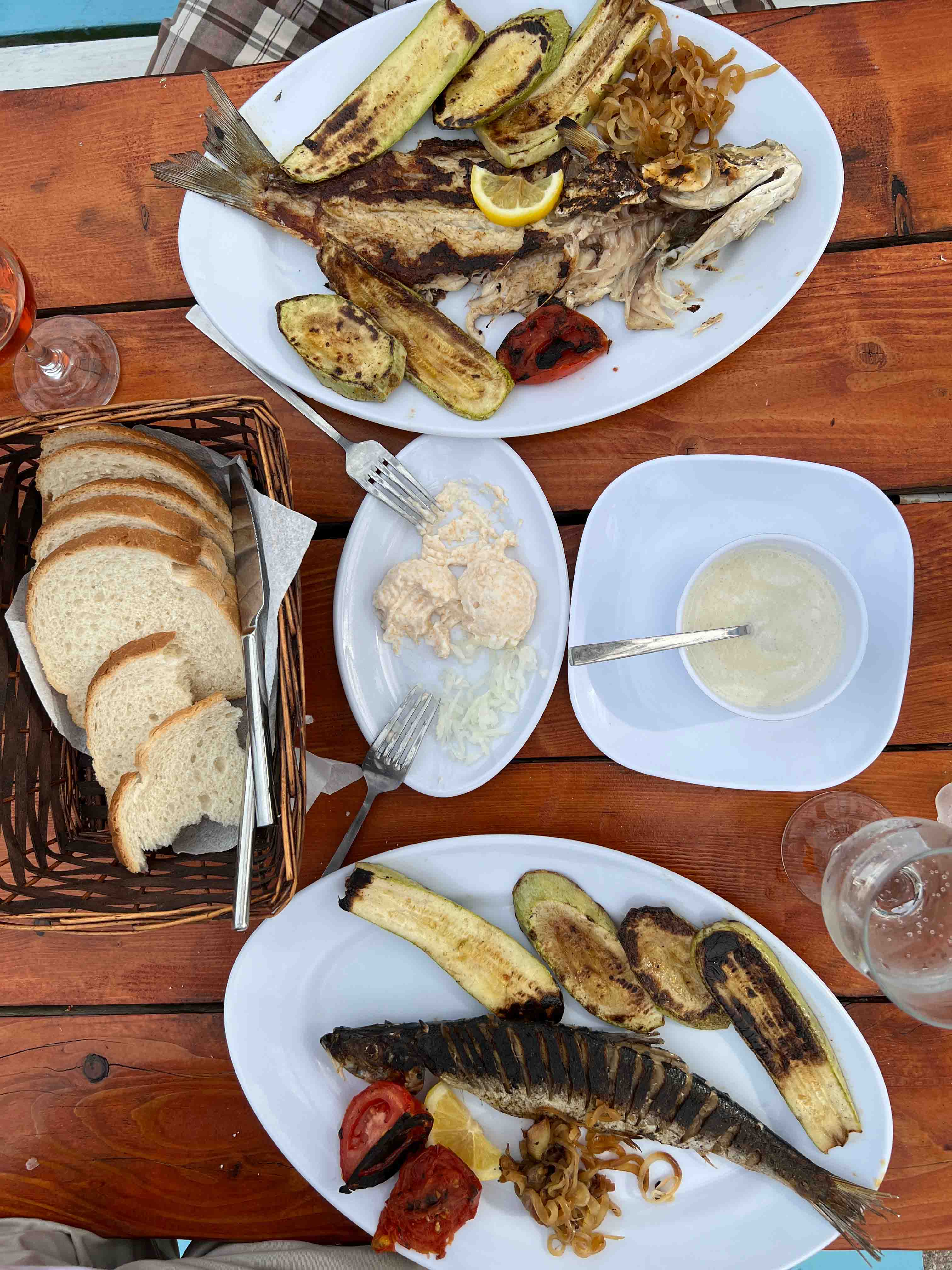Fish and bread served with veggies and sauce.